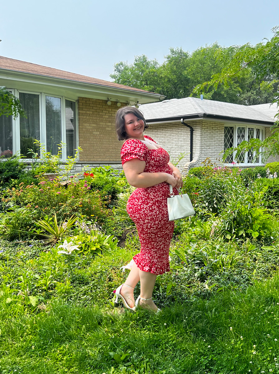 Coach is a garden, posing for a photo weeatring flower dress.